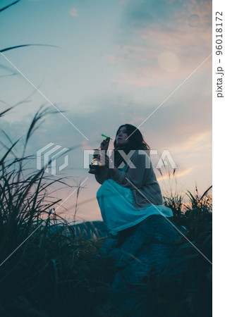 夕暮れの自然の中で佇む女性の写真 夕暮れの自然の中で佇む女性の写真 96018172