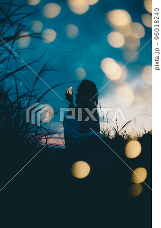 夕暮れの自然の中で佇む女性のシルエット写真 96018240