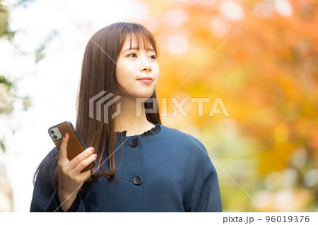 屋外を歩くコートの女性 96019376