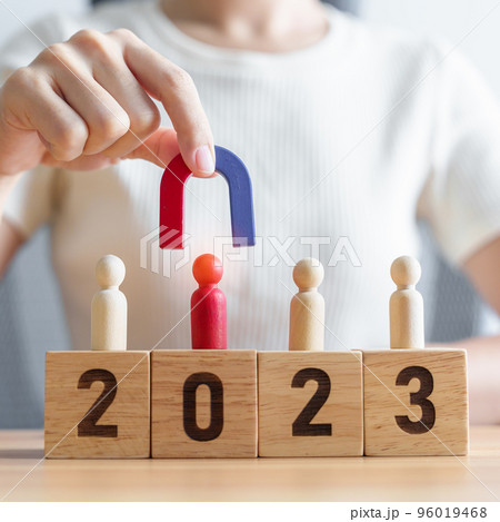 hand holding magnet and pulling man wooden figure from the crowd employee with 2023 Year block. Human resource management, Recruitment, Teamwork, strategy, toxic people and leadership Concepts hand holding magnet and pulling man wooden figure from the crowd employee with 2023 Year block. Human resource management, Recruitment, Teamwork, strategy, toxic people and leadership Concepts 96019468