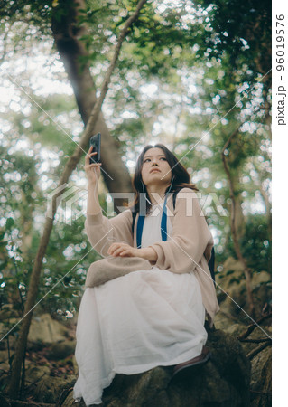 自然の中で音楽を聴く女性の写真 自然の中で音楽を聴く女性の写真 96019576