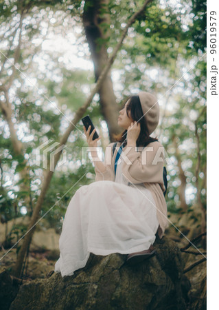 自然の中で音楽を聴く女性の写真 自然の中で音楽を聴く女性の写真 96019579