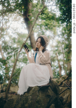 自然の中で音楽を聴く女性の写真 96019580
