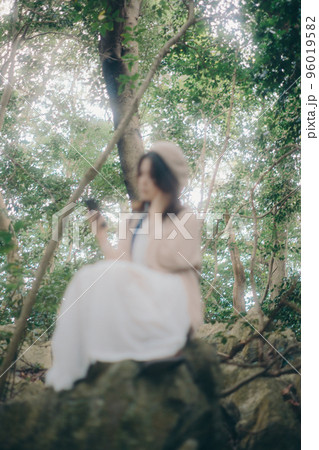 自然の中で音楽を聴く女性の写真 96019582