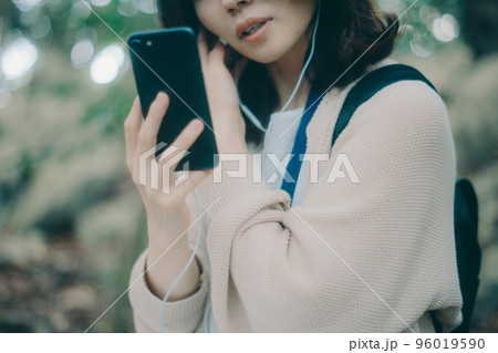 自然の中で音楽を聴く女性の写真 自然の中で音楽を聴く女性の写真 96019590