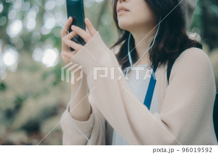 自然の中で音楽を聴く女性の写真 自然の中で音楽を聴く女性の写真 96019592