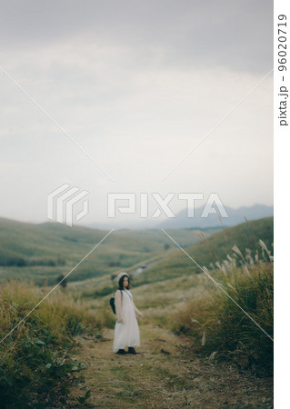 自然の中でカメラを持ってハイキングをする女性の写真 96020719