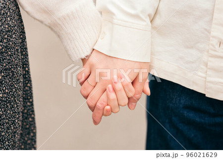 横に並んで手を繋ぐカップルの手元 96021629