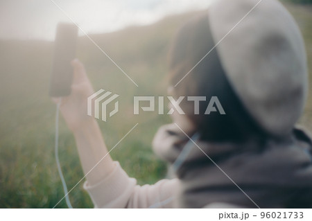 自然の中で音楽を聴く女性の写真 96021733