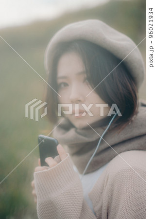 自然の中で音楽を聴く女性の写真 96021934