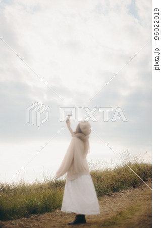 自然の中で音楽を聴く女性の写真 自然の中で音楽を聴く女性の写真 96022019