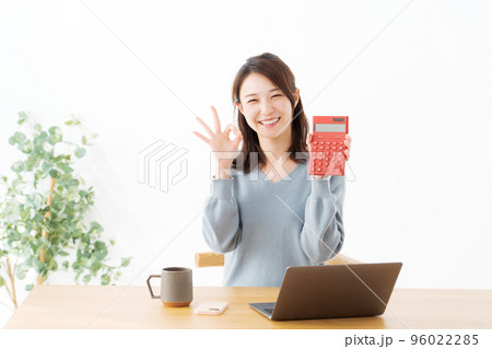 電卓を持つ女性 96022285