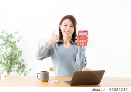 電卓を持つ女性 96022286