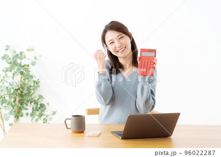 電卓を持つ女性 96022287