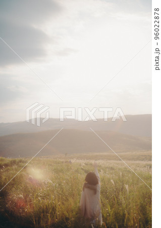 夕暮れの自然の中で音楽を聴く女性の写真 夕暮れの自然の中で音楽を聴く女性の写真 96022878