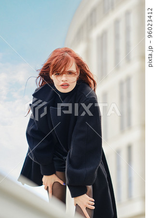 Tense woman has her hands on her knees and is staring intently ahead 96023412