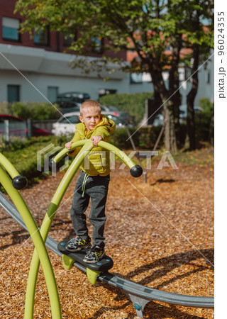 Funny cute happy baby playing on the playground. The emotion of happiness, fun, joy. Smile of a child. boy playing on the playground 96024355