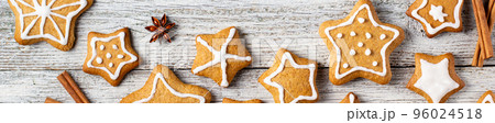 Border of Christmas gingerbreads in the shape of a star with patterns of glaze and spices on a white wooden background. Border of Christmas gingerbreads in the shape of a star with patterns of glaze and spices on a white wooden background. 96024518