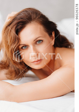 sexy naked brunette woman lying in bed. women's health and attractiveness. 96026378