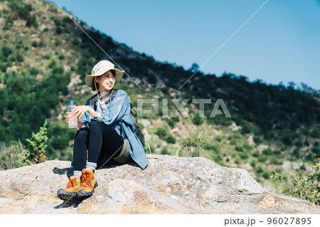 山上で水を飲む女性 96027895