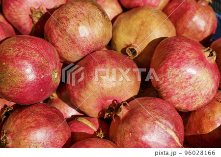 Juicy ripe pomegranate fruits on the market counter for juice. Pomegranate harvest on agricultural farm, vitamins, fruits, tropics concept. Juicy ripe pomegranate fruits on the market counter for juice. Pomegranate harvest on agricultural farm, vitamins, fruits, tropics concept. 96028166