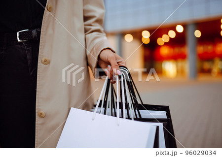 Young woman with shopping bags near mall. Spring Style. Consumerism, purchases, shopping, lifestyle. Young woman with shopping bags near mall. Spring Style. Consumerism, purchases, shopping, lifestyle. 96029034