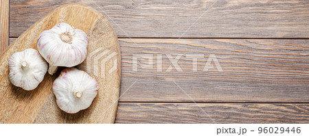 Garlic bulbs on a wooden chopping board. Copy space. 96029446