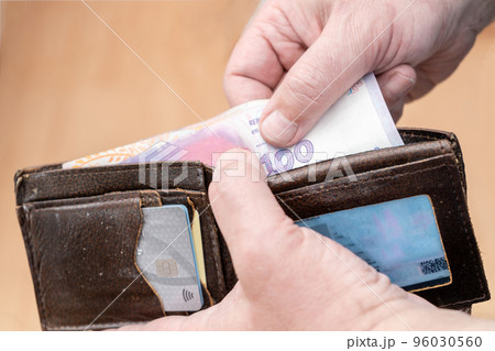 Close-up of a man's hands removing a bill from a wallet. Concept finance, business, inflation. Close-up of a man's hands removing a bill from a wallet. Concept finance, business, inflation. 96030560