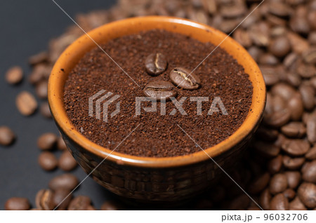 A cup of coffee with beans scattered nearby A cup of coffee with beans scattered nearby 96032706