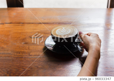 Woman hand holding a cup of coffee in cafe. Woman hand holding a cup of coffee in cafe. 96033347