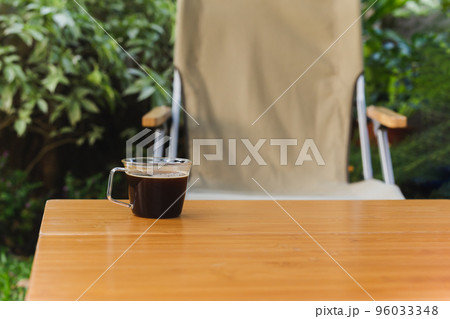 Cup of black coffee on wooden table in the garden. 96033348