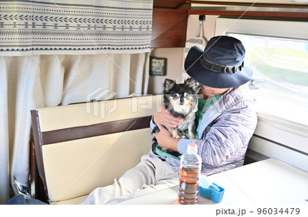 キャンピングカーでチワワとくつろぐ男性 96034479