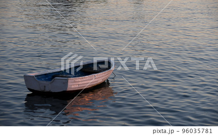 Small boat on the shore at sunset Small boat on the shore at sunset 96035781