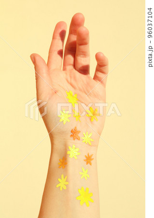 Female hand with painted flowers on beige background Female hand with painted flowers on beige background 96037104