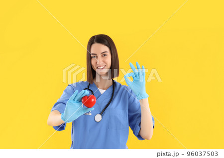 Attractive young female doctor on yellow background 96037503