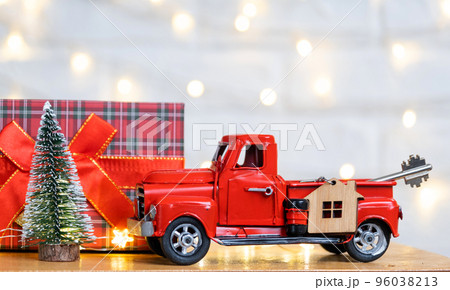 Red retro car with a Christmas tree decorates with the house key in the pickup truck for Christmas. Buying a home, moving, mortgage, loan, real estate, festive mood, New Year Red retro car with a Christmas tree decorates with the house key in the pickup truck for Christmas. Buying a home, moving, mortgage, loan, real estate, festive mood, New Year 96038213