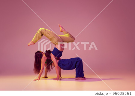 Contemporary dance couple in motion and action isolated on crystal pink background. Young stylish fashionable girls dancing. Art, fashion, style Contemporary dance couple in motion and action isolated on crystal pink background. Young stylish fashionable girls dancing. Art, fashion, style 96038361