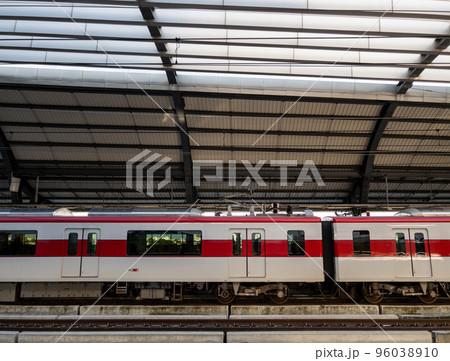 The electric train stops to pick up passengers at a suburban station. 96038910
