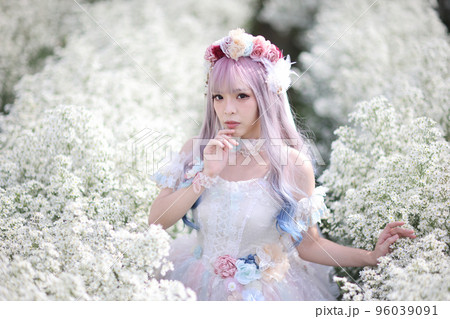 Portrait of Asian young woman with lolita fashion dress in white flower garden background 96039091