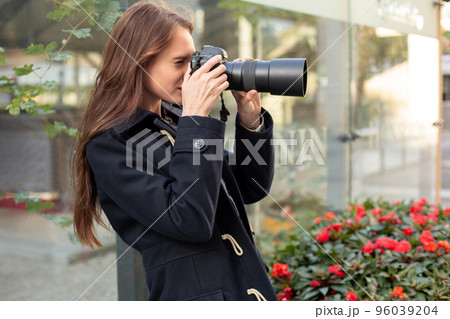 Happy woman on vacation photographing with camera on the city street 96039204