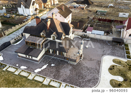 Aerial top view of new residential house cottage with shingle roof on fenced big yard on sunny day. Aerial top view of new residential house cottage with shingle roof on fenced big yard on sunny day. 96040093
