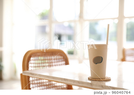Iced coffee with paper glass in coffee shop background Iced coffee with paper glass in coffee shop background 96040764