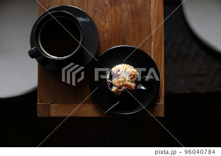 Coffee cup with muffin on wood table in local coffee shop Coffee cup with muffin on wood table in local coffee shop 96040784