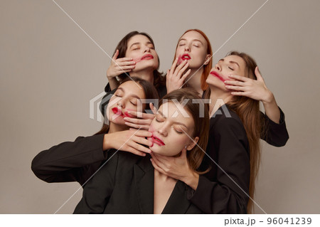 Portrait of young beautiful women in black jackets and red lipstick posing over grey background. Smeared makeup Portrait of young beautiful women in black jackets and red lipstick posing over grey background. Smeared makeup 96041239