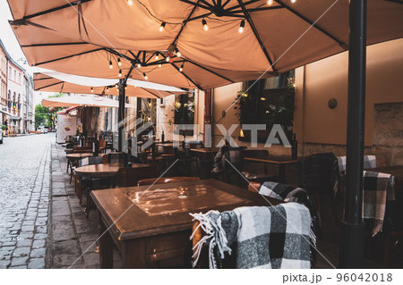 Spend time on terrace: cozy street cafe interior with wooden wicker chairs and blooming hydrangea. Garden or dacha restaurant outside city. Stylish patio at hotel or spa. Design and decoration concept Spend time on terrace: cozy street cafe interior with wooden wicker chairs and blooming hydrangea. Garden or dacha restaurant outside city. Stylish patio at hotel or spa. Design and decoration concept 96042018
