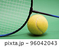 A Tennis ball and racket on the green background 96042043