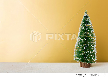 One small Christmas tree on colored background. new year decoration with copy space 96042068
