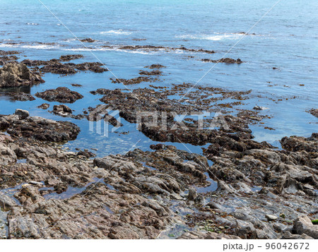 Rocky seashore, landscape. Calm water surface on a sunny day. 96042672
