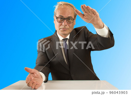businessman looking forward confidently opening his hands with blue background 96043903