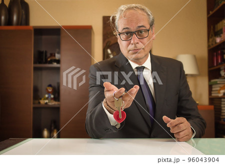businessman showing house keys with confident and relaxed expression 96043904